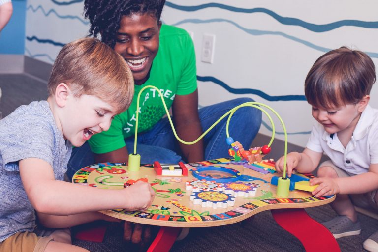 sitter with 2 kids playing