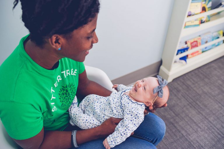 Sitter holding newborn