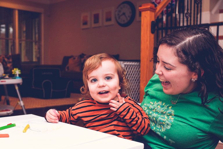 child and sitter sitting at table