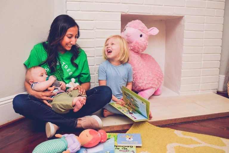 Sitter with toddler and baby reading