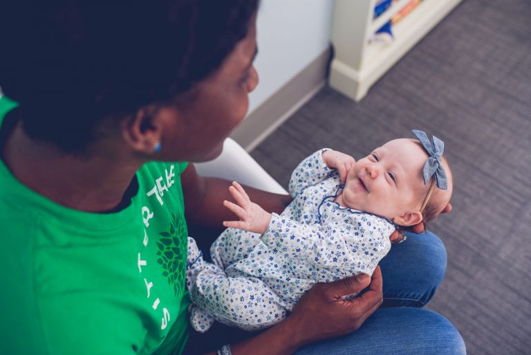 female sitter holding female infant