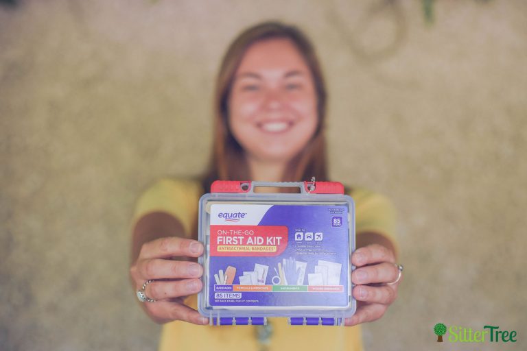 babysitter holds a first aid/ safety kit