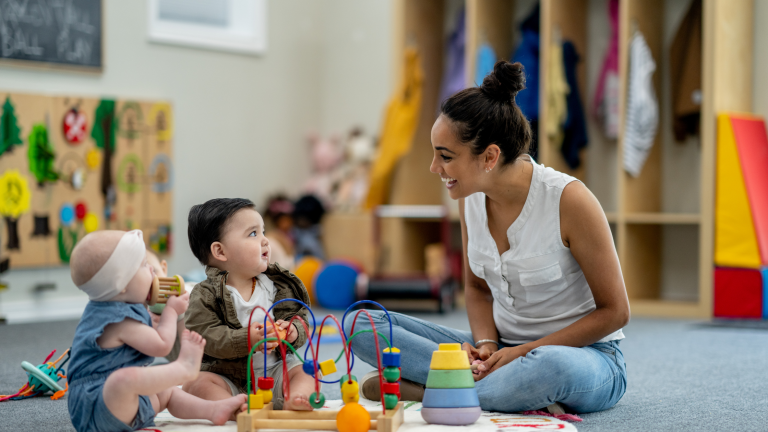 a daycare teacher plays with children