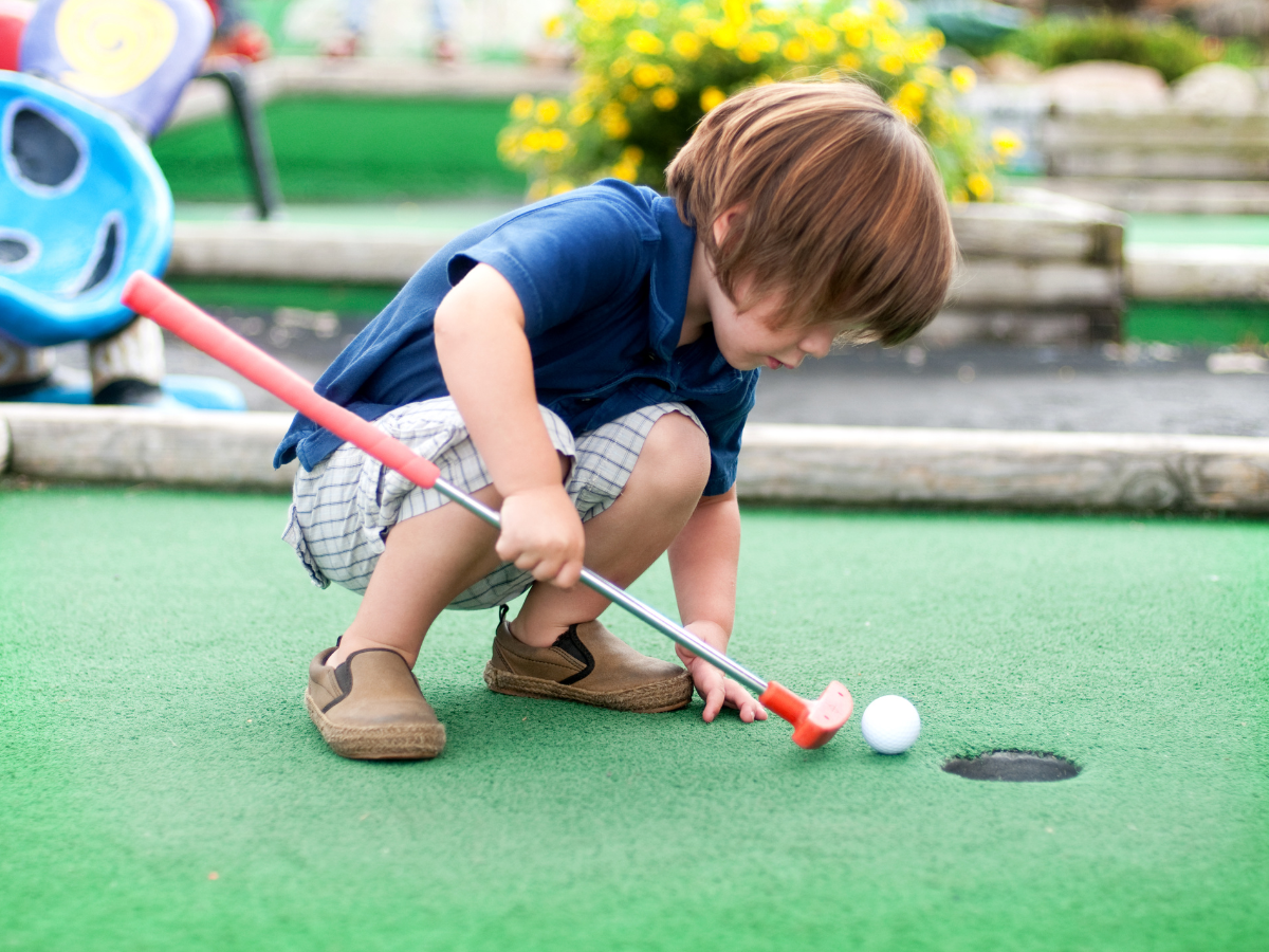 Things to Do in Austin with Kids: boy playing mini golf