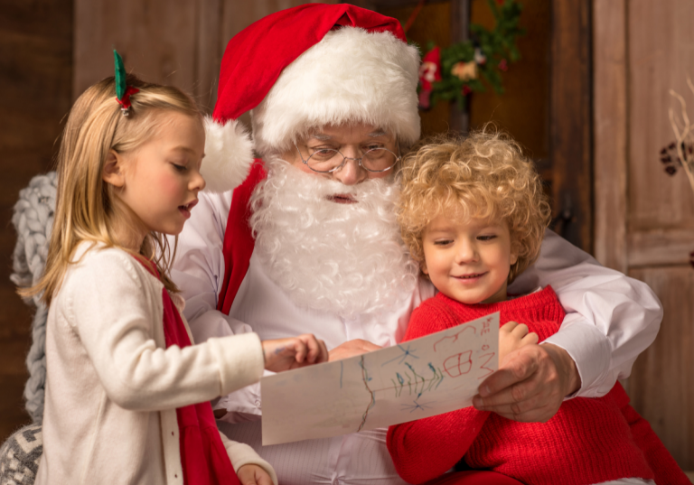 Photos with Santa in Denver: Santa Claus reading a Christmas list with two smiling children, one girl and one boy, in a cozy holiday setting